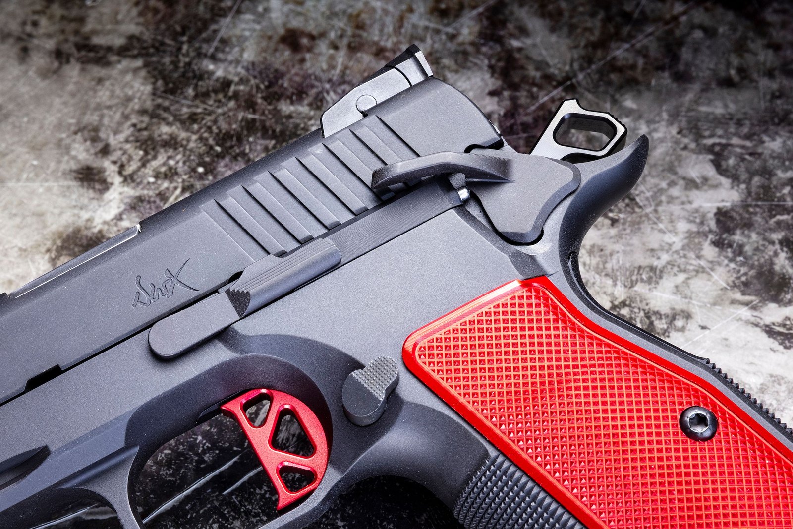 Détail de la carcasse du Dan Wesson DWX : détente à course courte et plaquettes rouges